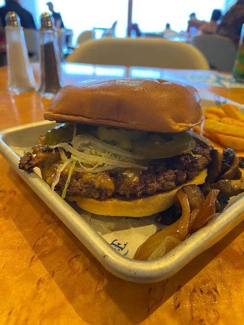 A burger (in paradise) on Margaritaville at Sea's Islander. A shaker of salt can be seen in the background. A burger (in paradise) on Margaritaville at Sea's Islander. A shaker of salt can be seen in the background.