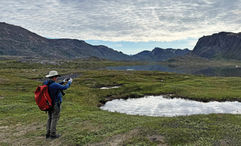 Lindblad's director of expedition photography, Rich Reid, shooting a landscape in western Greenland in July. The company will begin implementing the new branding on National Geographic-Lindblad Expeditions ships next year.